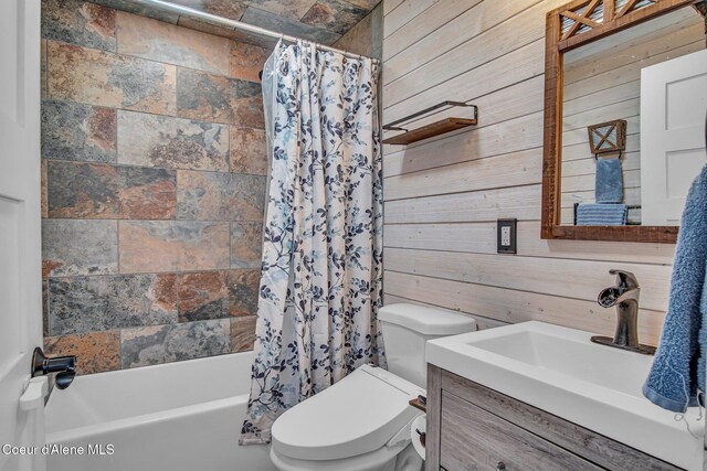 full bathroom with wooden walls, toilet, shower / tub combo with curtain, and vanity