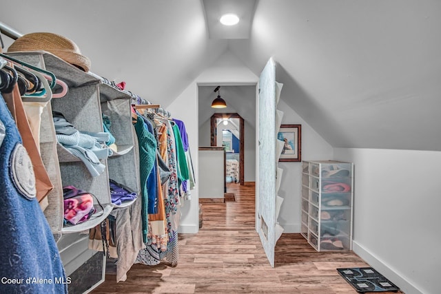 spacious closet featuring wood finished floors and vaulted ceiling