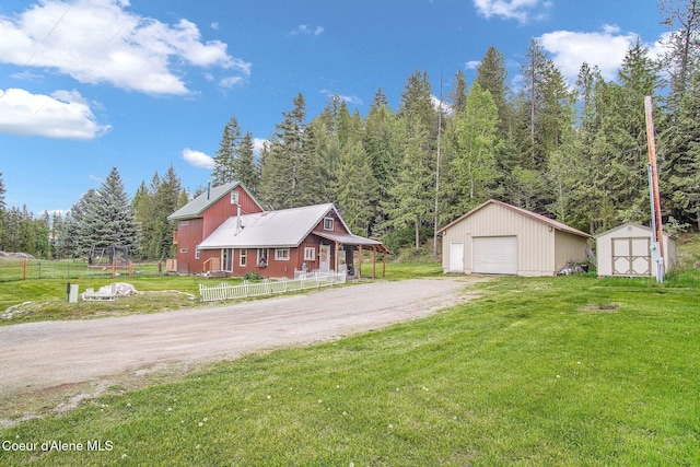 view of side of property featuring an outbuilding, dirt driveway, a garage, and a shed