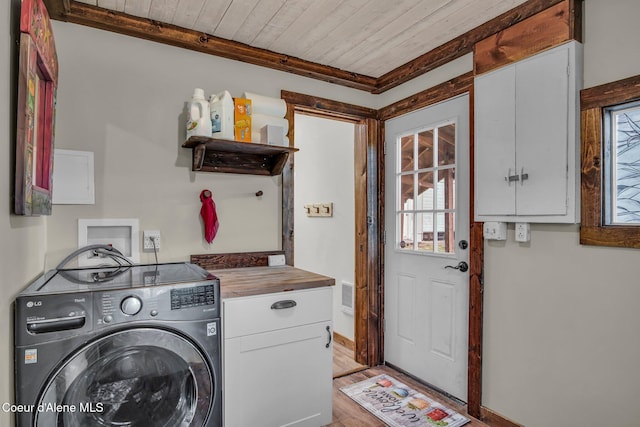 clothes washing area with washer / dryer, cabinet space, wooden ceiling, light wood-style floors, and baseboards