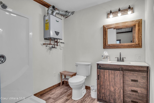 bathroom featuring wood finished floors, toilet, tankless water heater, vanity, and a shower