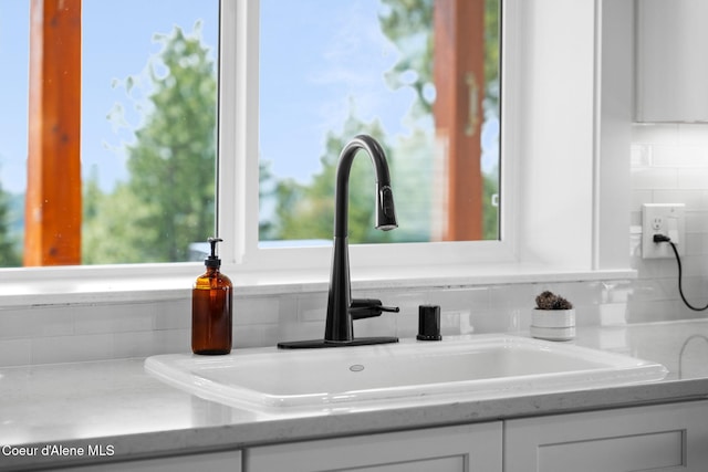 3298 W Coon Creek Rd, Plummer, ID 83851 - kitchen view of a sink, white cabinets, backsplash, and light countertops