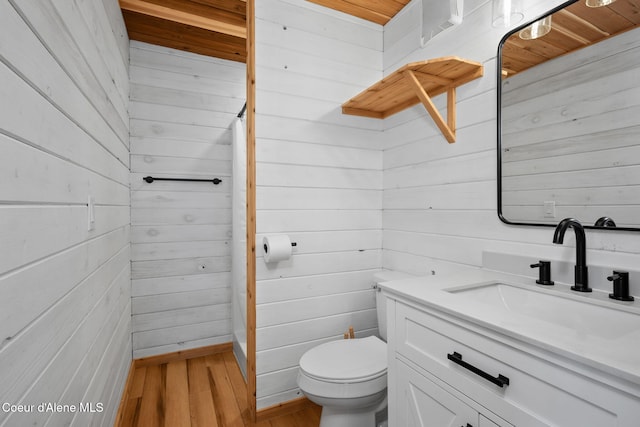 3298 W Coon Creek Rd, Plummer, ID 83851 - bathroom featuring wooden walls, toilet, vanity, and wood finished floors