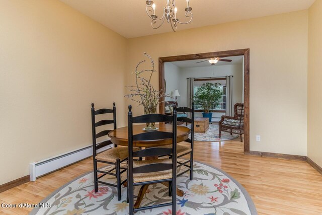 684 Chute Canyon Way, Bonners Ferry, ID 83805 - dining space featuring light wood-style flooring, a chandelier, a baseboard radiator, baseboards, and ceiling fan
