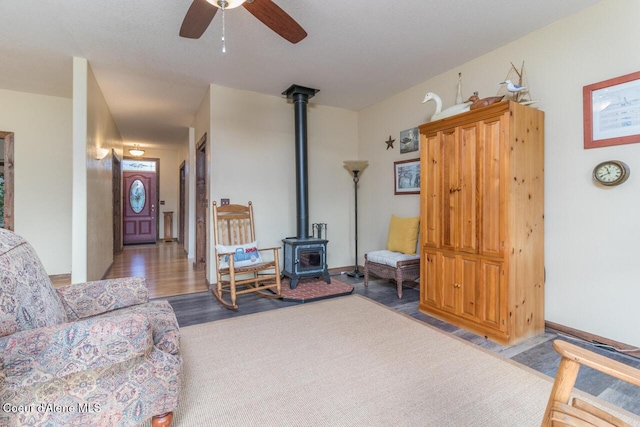 684 Chute Canyon Way, Bonners Ferry, ID 83805 - living room featuring a wood stove, ceiling fan, wood finished floors, and baseboards