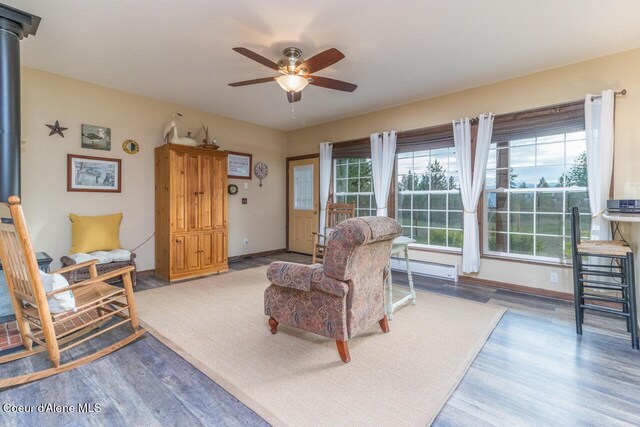 684 Chute Canyon Way, Bonners Ferry, ID 83805 - living area featuring a baseboard radiator, ceiling fan, wood finished floors, and plenty of natural light