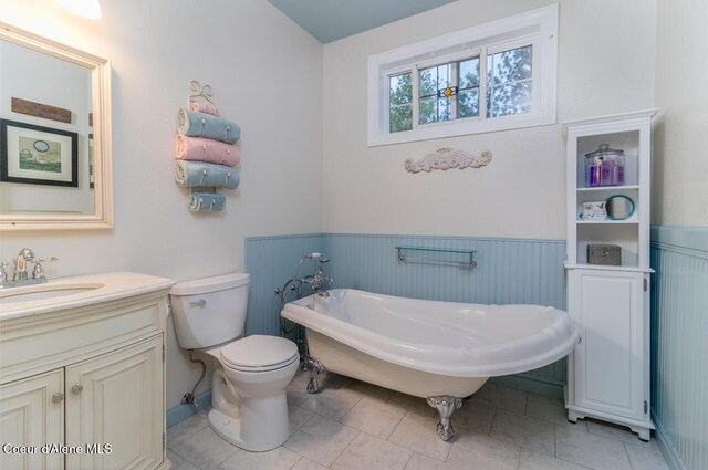 684 Chute Canyon Way, Bonners Ferry, ID 83805 - full bathroom with a wainscoted wall, a freestanding bath, toilet, vanity, and tile patterned floors