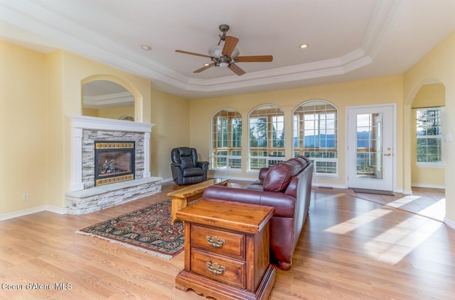 684 Chute Canyon Way, Bonners Ferry, ID 83805 - living area with ornamental molding, a stone fireplace, light wood finished floors, a raised ceiling, and a ceiling fan