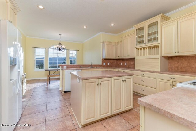 684 Chute Canyon Way, Bonners Ferry, ID 83805 - kitchen with white appliances, cream cabinetry, a sink, a peninsula, and crown molding