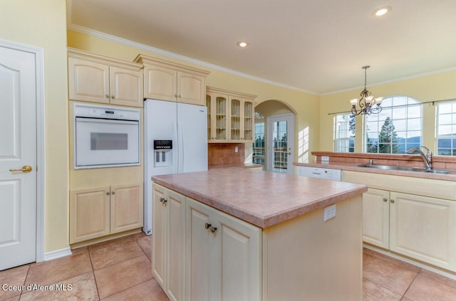 684 Chute Canyon Way, Bonners Ferry, ID 83805 - kitchen featuring white appliances, a sink, cream cabinets, crown molding, and arched walkways