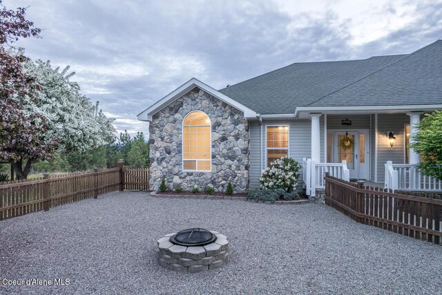 684 Chute Canyon Way, Bonners Ferry, ID 83805 - view of front of property featuring an outdoor fire pit, fence, roof with shingles, and a porch