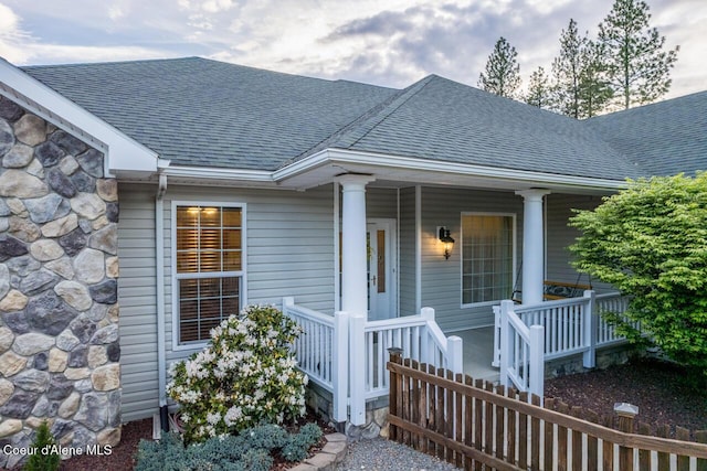 684 Chute Canyon Way, Bonners Ferry, ID 83805 - property entrance with roof with shingles, covered porch, and stone siding