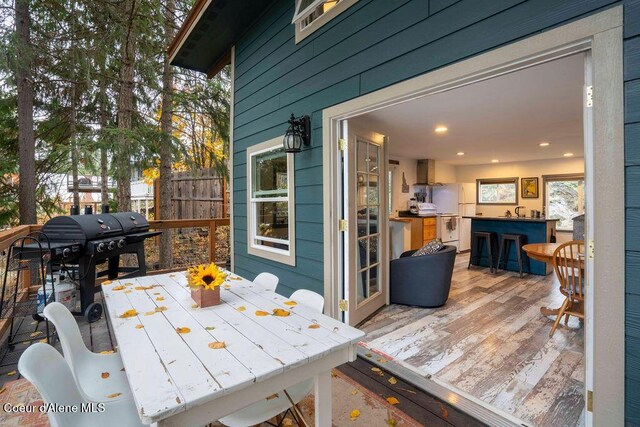 7547 W Channel Ln, Rathdrum, ID 83858 - wooden deck featuring outdoor dining space and a grill