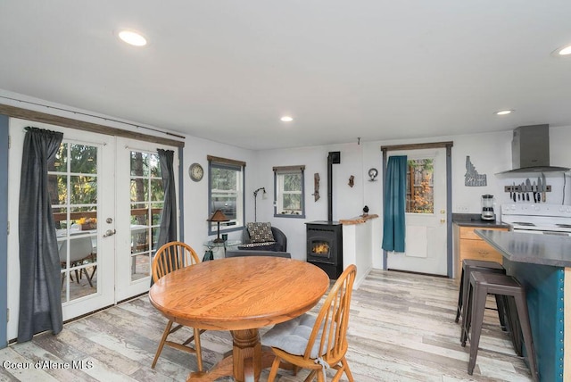 7547 W Channel Ln, Rathdrum, ID 83858 - dining area featuring a wood stove, french doors, light wood-style flooring, and recessed lighting