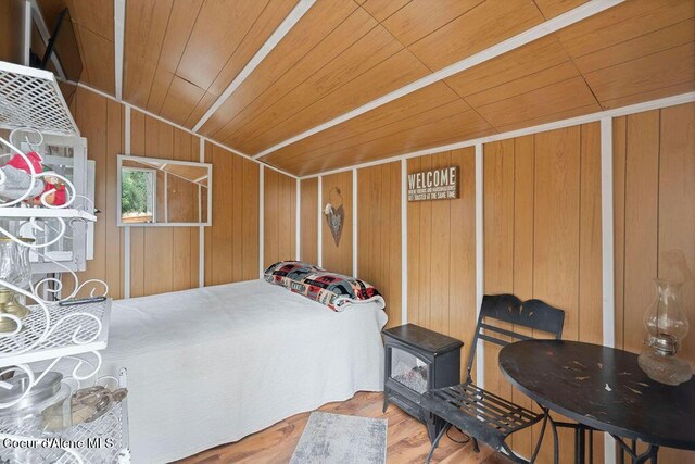 7547 W Channel Ln, Rathdrum, ID 83858 - bedroom with wood ceiling, lofted ceiling, wooden walls, wood finished floors, and a wood stove