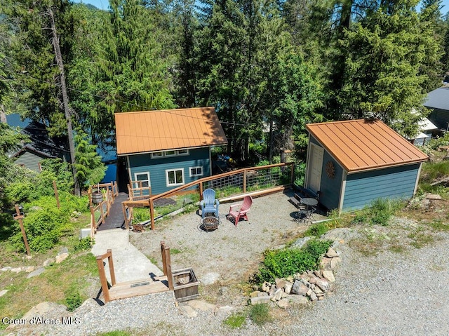 7547 W Channel Ln, Rathdrum, ID 83858 - view of front of house with a standing seam roof, an outdoor fire pit, metal roof, and an outdoor structure