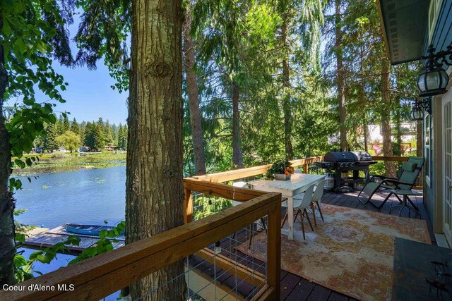 7547 W Channel Ln, Rathdrum, ID 83858 - wooden deck with a water view, grilling area, and outdoor dining space