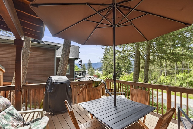 16646 E Cape Horn Rd, Bayview, ID 83803 - wooden deck with outdoor dining space, a mountain view, and a grill