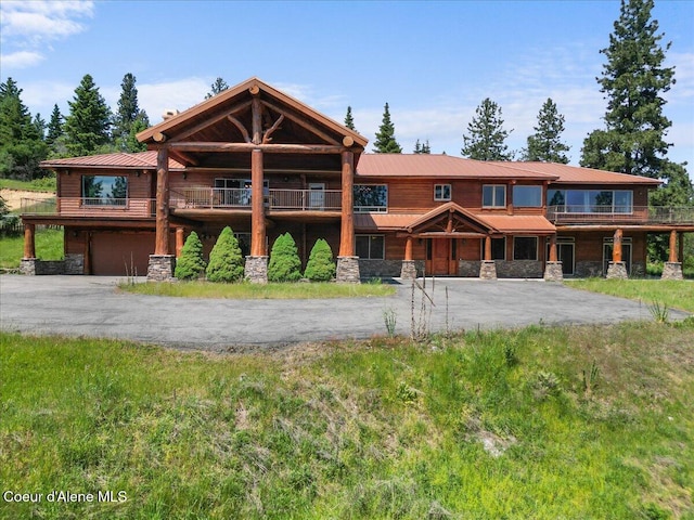 5239 E Dodd Rd, Hayden, ID 83835 - log-style house with stone siding, driveway, a garage, a balcony, and metal roof