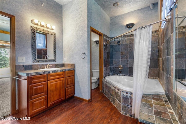 5239 E Dodd Rd, Hayden, ID 83835 - full bathroom with tiled shower / bath, toilet, wood finished floors, vanity, and a textured wall