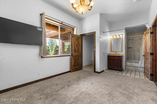 5239 E Dodd Rd, Hayden, ID 83835 - unfurnished bedroom with carpet, a chandelier, baseboards, and connected bathroom