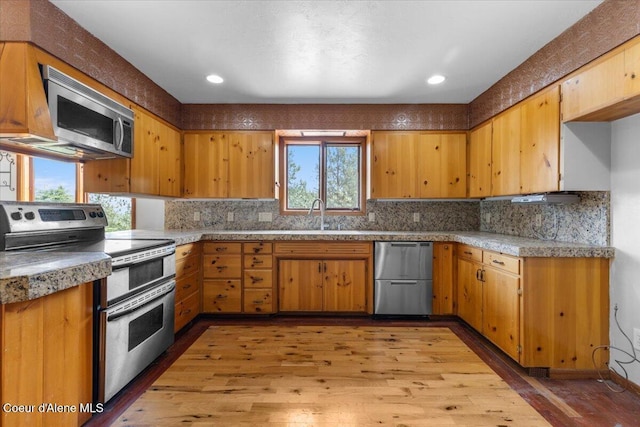 5239 E Dodd Rd, Hayden, ID 83835 - kitchen featuring stainless steel appliances, a sink, light wood-style flooring, tasteful backsplash, and recessed lighting