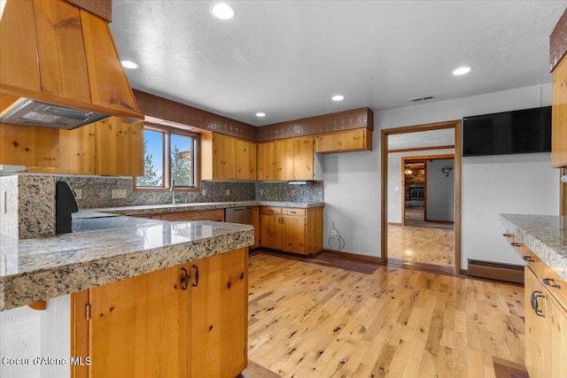 5239 E Dodd Rd, Hayden, ID 83835 - kitchen featuring custom exhaust hood, brown cabinetry, light wood-style flooring, decorative backsplash, and recessed lighting