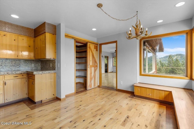 5239 E Dodd Rd, Hayden, ID 83835 - kitchen with light wood finished floors, tasteful backsplash, baseboards, a chandelier, and light countertops