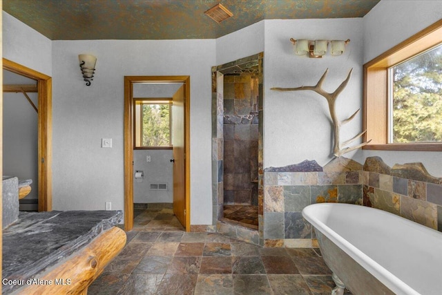 5239 E Dodd Rd, Hayden, ID 83835 - bathroom with a soaking tub, stone tile flooring, and a tile shower