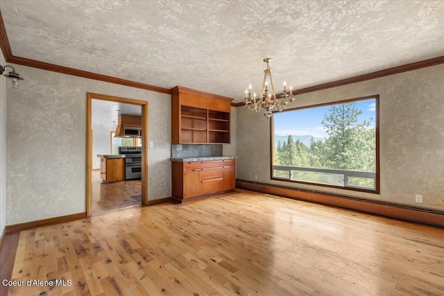 5239 E Dodd Rd, Hayden, ID 83835 - kitchen with stainless steel appliances, a textured wall, a baseboard radiator, ornamental molding, and light wood-style flooring