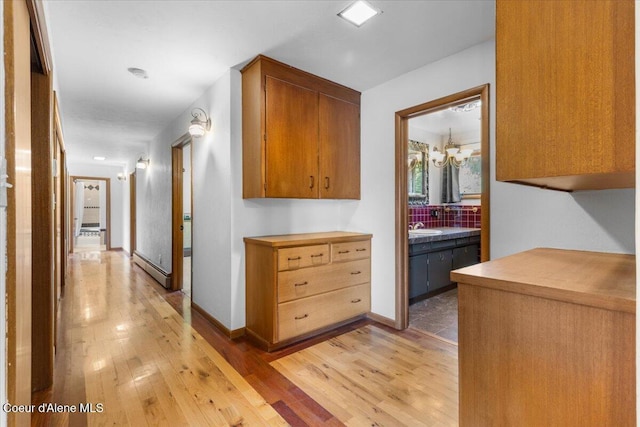 5239 E Dodd Rd, Hayden, ID 83835 - hallway with light wood-type flooring, a sink, a baseboard radiator, and baseboards