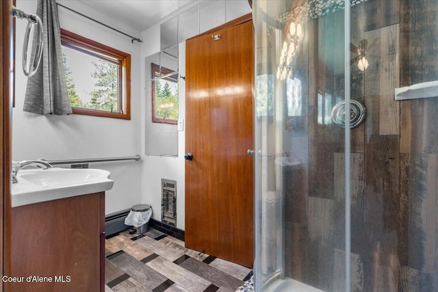 5239 E Dodd Rd, Hayden, ID 83835 - bathroom featuring a stall shower, vanity, and a baseboard heating unit