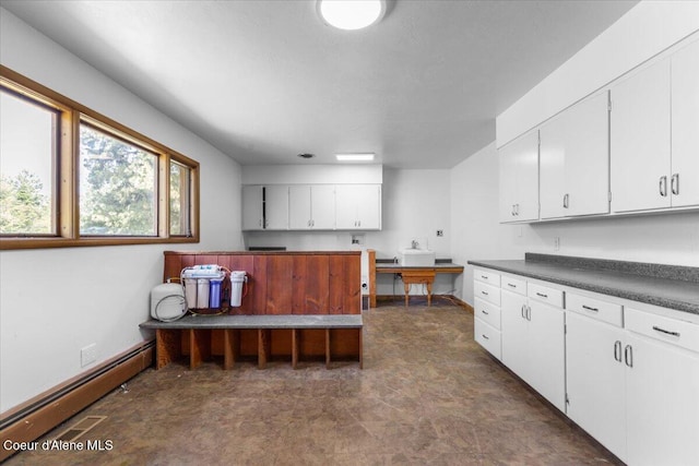 5239 E Dodd Rd, Hayden, ID 83835 - kitchen with baseboard heating, white cabinets, dark countertops, and baseboards
