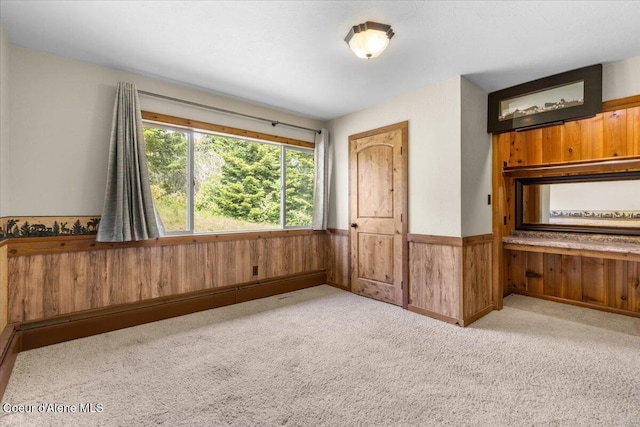 5239 E Dodd Rd, Hayden, ID 83835 - unfurnished bedroom featuring wood walls, carpet, and wainscoting