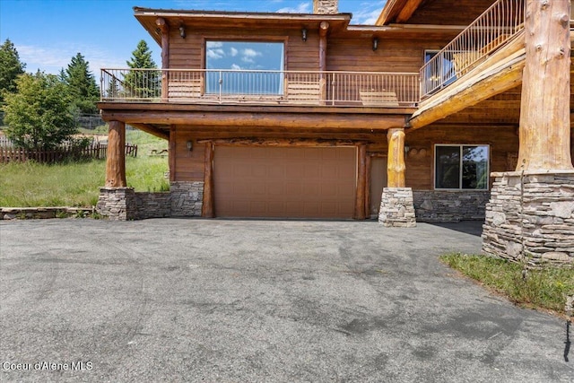 5239 E Dodd Rd, Hayden, ID 83835 - view of front of property featuring a balcony, a garage, stone siding, driveway, and a chimney