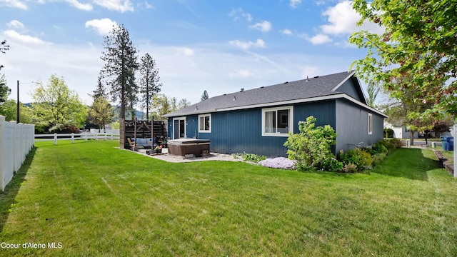 back of property featuring a hot tub, a patio, and roof with shingles