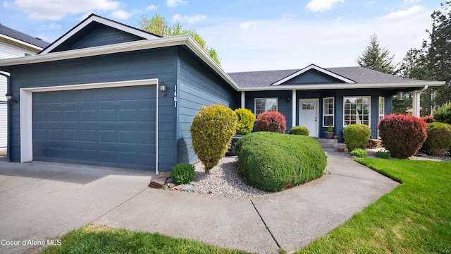 ranch-style house featuring a garage, concrete driveway, a shingled roof, and a front lawn