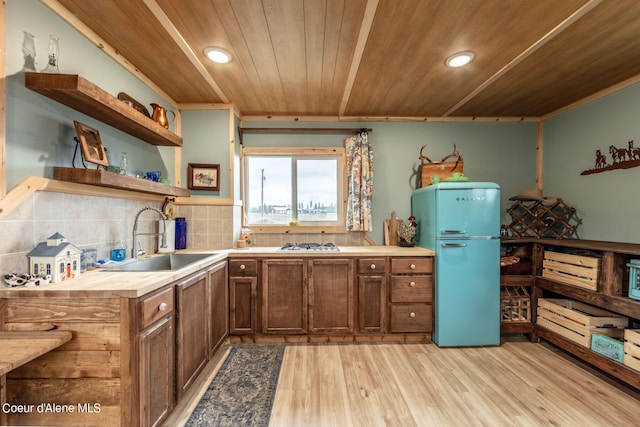 kitchen featuring freestanding refrigerator, a sink, wooden ceiling, open shelves, and light wood-type flooring