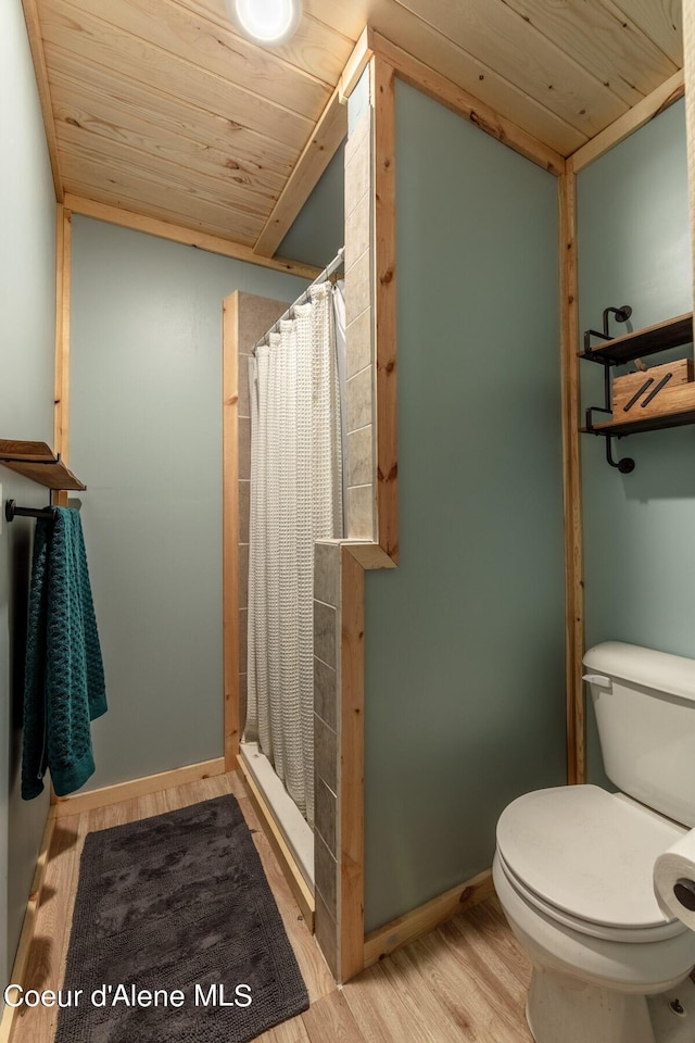 bathroom with wooden ceiling, toilet, a stall shower, wood finished floors, and lofted ceiling