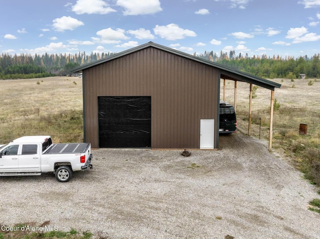 garage with a detached garage and gravel driveway