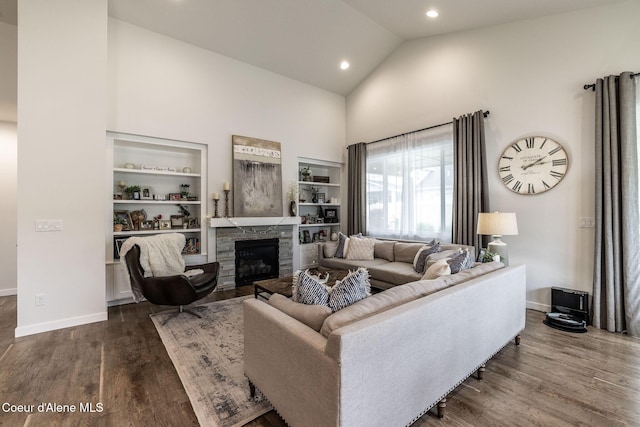 1769 N Chetco Dr, Post Falls, ID 83854 - living room with high vaulted ceiling, wood finished floors, built in shelves, baseboards, and a fireplace
