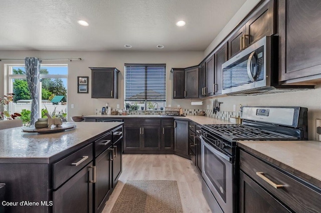 3316 N Van Winkle St, Post Falls, ID 83854 - kitchen featuring appliances with stainless steel finishes, light wood-style floors, recessed lighting, dark brown cabinets, and a sink