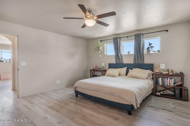 3316 N Van Winkle St, Post Falls, ID 83854 - bedroom featuring light wood-style flooring, arched walkways, ceiling fan, and baseboards
