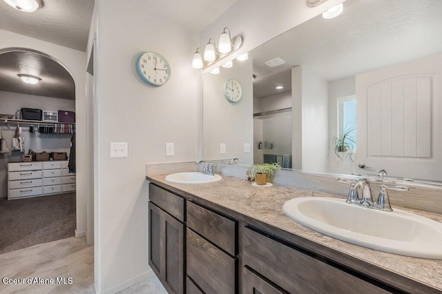 3316 N Van Winkle St, Post Falls, ID 83854 - full bathroom featuring a shower stall, double vanity, a spacious closet, and baseboards