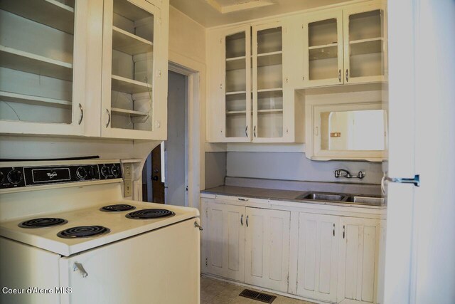 2224 N Park Rd, Spokane Valley, WA 99212 - kitchen featuring white range with electric cooktop, a sink, glass insert cabinets, and white cabinetry