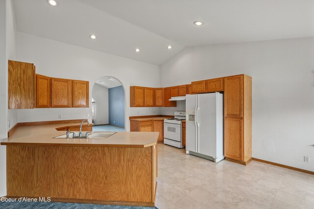kitchen with white appliances, a sink, a peninsula, high vaulted ceiling, and arched walkways