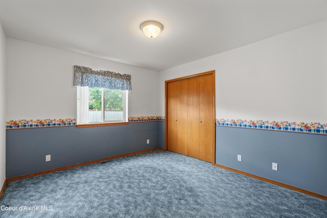 unfurnished bedroom with carpet floors, baseboards, and a closet