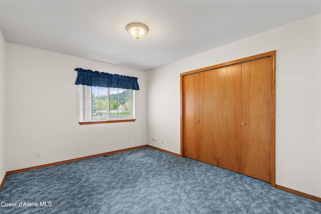 unfurnished bedroom with carpet, baseboards, and a closet