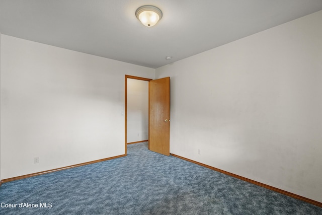 carpeted empty room featuring baseboards
