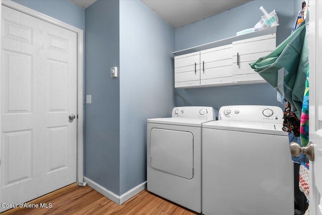 1135 W Wishkah Ave, Post Falls, ID 83854 - laundry room featuring washer and clothes dryer, light wood-type flooring, baseboards, and cabinet space